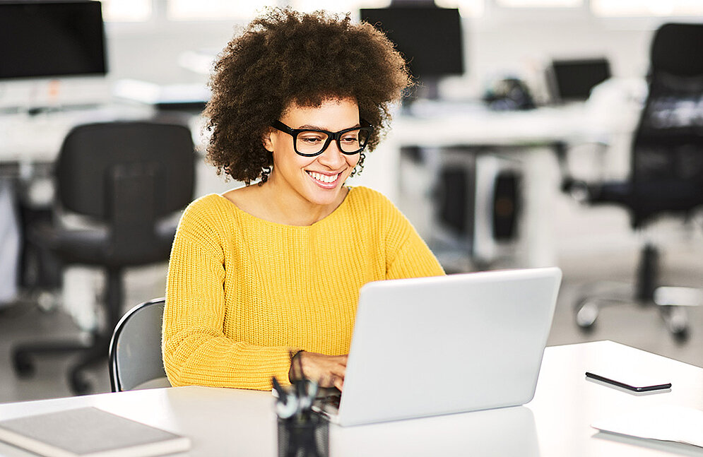 La mujer aprende con placer en el ordenador portátil